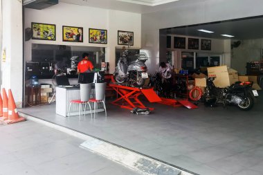 KANCHANABURI-THAILAND, 20 Temmuz 2023: Yamaha motosiklet atölyesi ve satış merkezi. LoHengMong tamirhanesinde teknisyen Yamaha motorsikletini tamir ediyor. Yamaha Motosiklet Tamir Servisi.