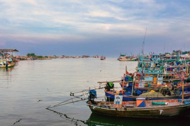 PHETCHABURI-THAILAND, Ekim 23, 2022: Akşam Phoo Chuk Köprüsü 'nde deniz manzaralı çeşitli renkli balıkçı teknelerinin güzel manzarası. Balıkçı tekneleri balıkçı köyüne yanaştı.