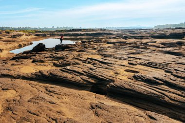 Kadın turist, Tayland 'daki Grand Canyon' da akıllı telefonla fotoğraf çekiyor. Mekong Nehri 'ndeki Nature of rock kanyonu. Dağ tepeli kuru kaya resifi. Sam Phan Bok 'un görüntüsüne Tayland Vadisi denir..