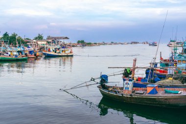 PHETCHABURI-THAILAND, Ekim 23, 2022: Akşam Phoo Chuk Köprüsü 'nde deniz manzaralı çeşitli renkli balıkçı teknelerinin güzel manzarası. Balıkçı tekneleri balıkçı köyüne yanaştı.