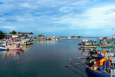 PHETCHABURI-THAILAND, 20 Ağustos 2022: Akşam Phoo Chuk Köprüsü 'nde deniz manzaralı çeşitli renkli balıkçı teknelerinin güzel manzarası. Balıkçı tekneleri balıkçı köyüne yanaştı.