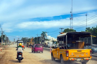 KANCHANABURI, THAILAND - 9 Eylül 2020: Thamuang Bölgesi 'nde karayolu inşaatı ve parlak turuncu trafik konileri ve kamyonları ile trafik sıkışıklıkları ve kazıcı veya kepçe yükleyici görülebiliyor.