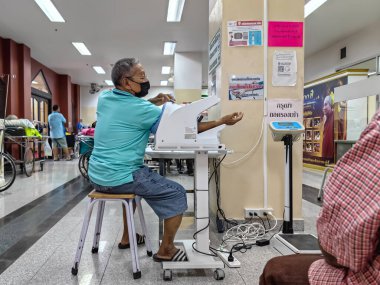 KANCHANABURI, THAILAND - 22 Ocak 2024: Tansiyonu ve kalp atışlarını Somdet Phra Sangharaja 19 Hastanesi 'ndeki otomatik dijital tansiyon makinesiyle kontrol edin.