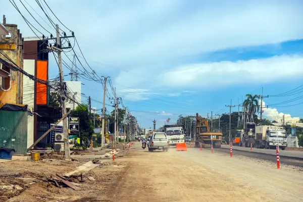 KANCHANABURI, THAILAND - 9 Eylül 2020: Thamuang Bölgesi 'nde karayolu inşaatı ve parlak turuncu trafik konileri ve kamyonları ile trafik sıkışıklıkları ve kazıcı veya kepçe yükleyici görülebiliyor.