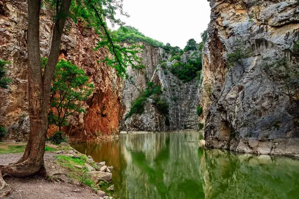 Beautiful nature scenic landscape with mountain range and beautiful hidden spot in Khao Ngu Stone Park at Ratchaburi, Thailand. Landscape view of mountain cliffs In green canyon lake. Amazing nature.