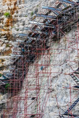 Tayland 'ın Suphan Buri kentindeki yeni turistik merkezin inşaat alanı olan uçurum tepesindeki gökdelen köprüsünün güzel manzarası. Yüksek uçurum boyunca cam yürüyüş yolu inşaatı