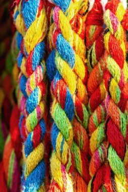 Renkli pamuklu ip. Kalın pamuklu ip iplik ve iplik detaylarını gösteriyor. Beşiğin ipli örgüsü. Çok renkli iplik örgüyle örülmüş. Örgü kumaş arka plan. Seçici odak.