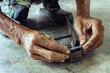 Kıdemli bir tamircinin elleri ve esnetilmiş çelik kapının sürgülü raylarında yeni tekerlekler. Sürgülü kapılara yeni çelik tekerlekler takıldı. Sürgülü kapı donanımı. Sürgülü kapıların ayarlanması