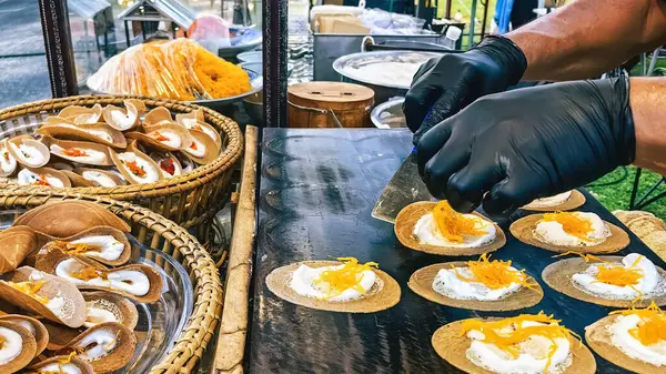 stock image Vendor wear glove make Thai Crispy Pancake or Kanom Buang on gas stove pan. A traditional Thai dessert menu with crispy flour and foi thong filling. Thai Style Crisp Tart, A kind of filled pancake