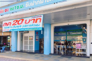KANCHANABURI, THAILAND-ARALIK 27,2023: Otteri 'deki genel müşterilere günün 24 saati otomatik çamaşır makinesi ile kuru temizleme atölyesinin görüntüsü. Kumaş temizleme işi konsepti.