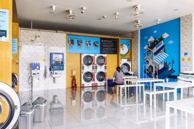 KANCHANABURI, THAILAND-FEBRUARY 6,2024 : View of laundry service shop with automatic washer dryer available to general customers 24 hours a day at Otteri wash and dry. Cloth cleaning business concept. clipart