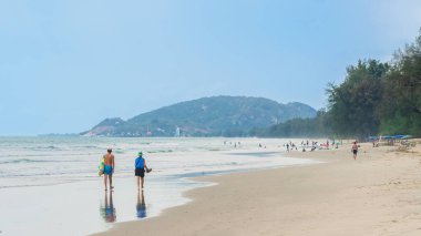 Sahilde birlikte yürüyen yaşlı aşıkların arka görüntüsü. Sahilde yürürken yaşlı bir çiftin portresi, yaşlılar yaşam tarzı, seyahat, doğada dinlenme. Aile sahilde kıyı boyunca yürür..