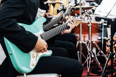 Gitarist erkek eller sahnede elektro gitar çalıyor. Klasik konser, performans provası, gösteri. Müzik aleti çalmayı öğreniyorum. Elektro gitar çalan gitaristin elleri.