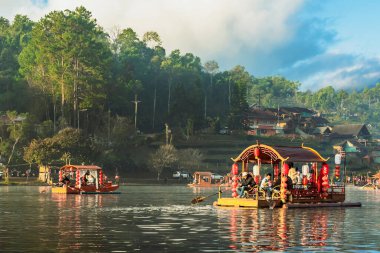 MAE HONG SON, THAILAND-DECEMBER 31,2024: Rak Thai Village Reservoir ya da Baan Rak Thai 'nin turistlerle dolu güzel manzarası ve antik Yunnan Çin tarzında bir göl manzaralı ahşap tekne alın