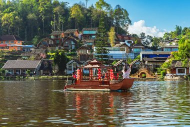 MAE HONG SON, THAILAND-DECEMBER 31,2024: Rak Thai Village Reservoir ya da Baan Rak Thai 'nin turistlerle dolu güzel manzarası ve antik Yunnan Çin tarzında bir göl manzaralı ahşap tekne alın