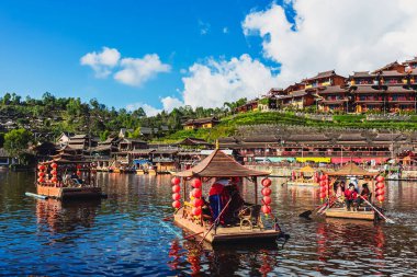 MAE HONG SON, THAILAND-DECEMBER 31,2024: Rak Thai Village Reservoir ya da Baan Rak Thai 'nin turistlerle dolu güzel manzarası ve antik Yunnan Çin tarzında bir göl manzaralı ahşap tekne alın