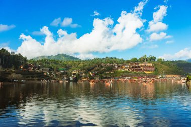 MAE HONG SON, THAILAND-DECEMBER 31,2024: Rak Thai Village Reservoir ya da Baan Rak Thai 'nin turistlerle dolu güzel manzarası ve antik Yunnan Çin tarzında bir göl manzaralı ahşap tekne alın