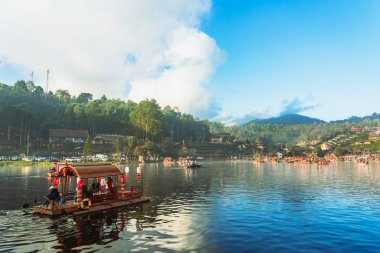 MAE HONG SON, THAILAND-DECEMBER 31,2024: Rak Thai Village Reservoir ya da Baan Rak Thai 'nin turistlerle dolu güzel manzarası ve antik Yunnan Çin tarzında bir göl manzaralı ahşap tekne alın