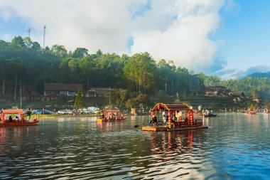 MAE HONG SON, THAILAND-DECEMBER 31,2024: Rak Thai Village Reservoir ya da Baan Rak Thai 'nin turistlerle dolu güzel manzarası ve antik Yunnan Çin tarzında bir göl manzaralı ahşap tekne alın