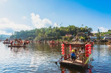 MAE HONG SON, THAILAND-DECEMBER 31,2024: Rak Thai Village Reservoir ya da Baan Rak Thai 'nin turistlerle dolu güzel manzarası ve antik Yunnan Çin tarzında bir göl manzaralı ahşap tekne alın