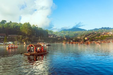 MAE HONG SON, THAILAND-DECEMBER 31,2024: Rak Thai Village Reservoir ya da Baan Rak Thai 'nin turistlerle dolu güzel manzarası ve antik Yunnan Çin tarzında bir göl manzaralı ahşap tekne alın