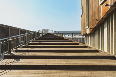 Modern sergi binasının girişinde ahşap merdiven ve yüzey dokusuyla döşenmiş güzel modern mimari konsept tasarımı. Güzel ahşap merdiven.