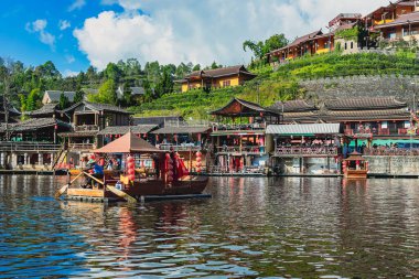 MAE HONG SON, THAILAND-DECEMBER 31,2024: Rak Thai Village Reservoir ya da Baan Rak Thai 'nin turistlerle dolu güzel manzarası ve antik Yunnan Çin tarzında bir göl manzaralı ahşap tekne alın