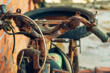 Eski Paslı Terk Edilmiş Eski Motosiklet. Eski, eski, paslı, bozuk bir motorsikletin parçası. Eski paslı bisiklet, motosiklet, motorlar, lastikler ve jantlı tekerlekler. Kullanılamayan eski motorsikletler