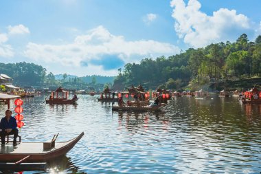 MAE HONG SON, THAILAND-DECEMBER 31,2024: Rak Thai Village Reservoir ya da Baan Rak Thai 'nin turistlerle dolu güzel manzarası ve antik Yunnan Çin tarzında bir göl manzaralı ahşap tekne alın