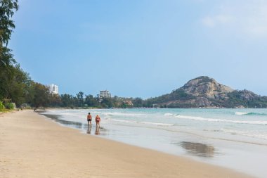 Sahilde birlikte yürüyen yaşlı aşıkların arka görüntüsü. Sahilde yürürken yaşlı bir çiftin portresi, yaşlılar yaşam tarzı, seyahat, doğada dinlenme. Aile sahilde kıyı boyunca yürür..