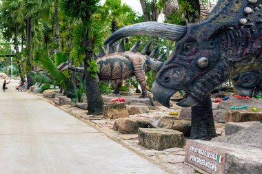 PATTAYA, THAILAND-DECEMBER 30. 2018: Nong Nooch Tropikal Botanik Bahçesi 'ndeki canlı benzeri manzaraya karşı heykeli veya çeşitli gerçekçi dinozor heykeli olan dinozor vadisi.