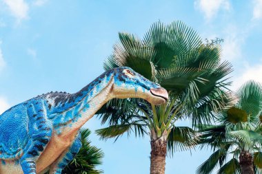 PATTAYA, THAILAND-DECEMBER 30. 2018: Nong Nooch Tropikal Botanik Bahçesi 'ndeki canlı benzeri manzaraya karşı heykeli veya çeşitli gerçekçi dinozor heykeli olan dinozor vadisi.