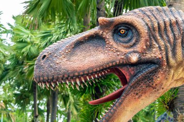 PATTAYA, THAILAND-DECEMBER 30. 2018: Nong Nooch Tropikal Botanik Bahçesi 'ndeki canlı benzeri manzaraya karşı heykeli veya çeşitli gerçekçi dinozor heykeli olan dinozor vadisi.