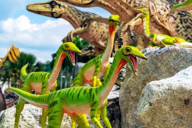 PATTAYA, THAILAND-DECEMBER 30. 2018: Nong Nooch Tropikal Botanik Bahçesi 'ndeki canlı benzeri manzaraya karşı heykeli veya çeşitli gerçekçi dinozor heykeli olan dinozor vadisi.