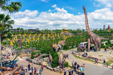 PATTAYA, THAILAND-DECEMBER 30. 2018: Nong Nooch Tropikal Botanik Bahçesi 'ndeki canlı benzeri manzaraya karşı heykeli veya çeşitli gerçekçi dinozor heykeli olan dinozor vadisi.
