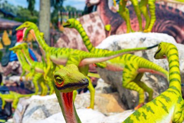 PATTAYA, THAILAND-DECEMBER 30. 2018: Nong Nooch Tropikal Botanik Bahçesi 'ndeki canlı benzeri manzaraya karşı heykeli veya çeşitli gerçekçi dinozor heykeli olan dinozor vadisi.