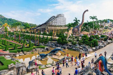 PATTAYA, THAILAND-DECEMBER 30. 2018: Nong Nooch Tropikal Botanik Bahçesi 'ndeki canlı benzeri manzaraya karşı heykeli veya çeşitli gerçekçi dinozor heykeli olan dinozor vadisi.