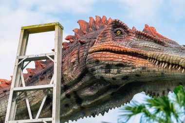 PATTAYA, THAILAND-DECEMBER 30. 2018: Nong Nooch Tropikal Botanik Bahçesi 'ndeki canlı benzeri manzaraya karşı heykeli veya çeşitli gerçekçi dinozor heykeli olan dinozor vadisi.