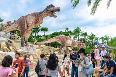 PATTAYA, THAILAND-DECEMBER 30. 2018: Nong Nooch Tropikal Botanik Bahçesi 'ndeki canlı benzeri manzaraya karşı heykeli veya çeşitli gerçekçi dinozor heykeli olan dinozor vadisi.