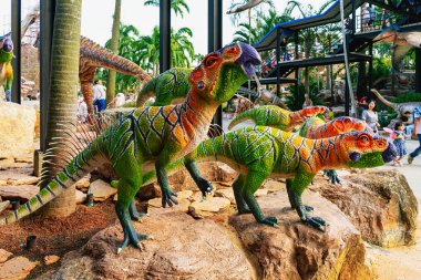 PATTAYA, THAILAND-DECEMBER 30. 2018: Nong Nooch Tropikal Botanik Bahçesi 'ndeki canlı benzeri manzaraya karşı heykeli veya çeşitli gerçekçi dinozor heykeli olan dinozor vadisi.