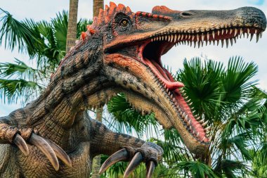 PATTAYA, THAILAND-DECEMBER 30. 2018: Nong Nooch Tropikal Botanik Bahçesi 'ndeki canlı benzeri manzaraya karşı heykeli veya çeşitli gerçekçi dinozor heykeli olan dinozor vadisi.
