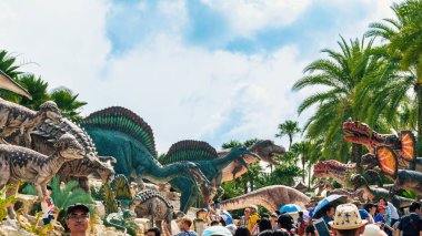 PATTAYA, THAILAND-DECEMBER 30. 2018: Nong Nooch Tropikal Botanik Bahçesi 'ndeki canlı benzeri manzaraya karşı heykeli veya çeşitli gerçekçi dinozor heykeli olan dinozor vadisi.