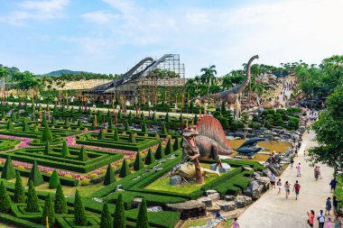 PATTAYA, THAILAND-DECEMBER 30. 2018: Nong Nooch Tropikal Botanik Bahçesi 'ndeki canlı benzeri manzaraya karşı heykeli veya çeşitli gerçekçi dinozor heykeli olan dinozor vadisi.