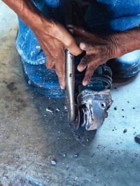 Su tesisatı bakım servisi evdeki kanalizasyon kanallarını değiştirmek için açılı öğütücü kullanıyor. Yaşlı adam kanalizasyon sisteminin lağım kapağını değiştirip onarıyor. Tuvalet drenaj sisteminin bakımı