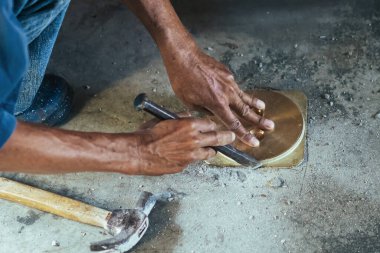 Su hizmetleri bakım servisinin yaşlı çalışanı evdeki kanalizasyon kanallarını değiştiriyor. Yaşlı adamın elleri kanalizasyon sisteminin lağım kapağını değiştirip onarıyor. Tuvalet drenaj sisteminin bakımı.