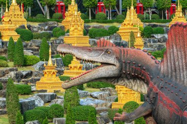PATTAYA, THAILAND-DECEMBER 30. 2018: Nong Nooch Tropikal Botanik Bahçesi 'ndeki canlı benzeri manzaraya karşı heykeli veya çeşitli gerçekçi dinozor heykeli olan dinozor vadisi.