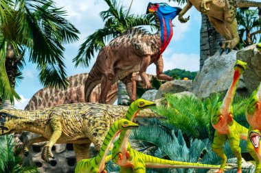 PATTAYA, THAILAND-DECEMBER 30. 2018: Nong Nooch Tropikal Botanik Bahçesi 'ndeki canlı benzeri manzaraya karşı heykeli veya çeşitli gerçekçi dinozor heykeli olan dinozor vadisi.