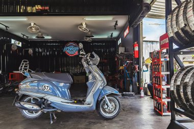 KANCHANABURI, THAILAND - 29 Nisan 2022 Motosiklet tamircisi ve mobilet lambası ampulü ya da motosiklet garajındaki ampulü değiştir. Baştaki lamba prizini değiştir..