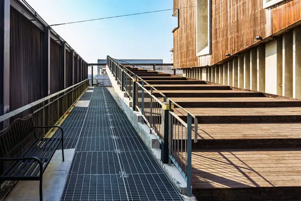 Modern sergi binasının girişinde ahşap merdiven ve yüzey dokusuyla döşenmiş güzel modern mimari konsept tasarımı. Güzel ahşap merdiven.