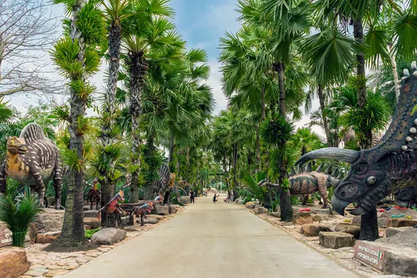 PATTAYA, THAILAND-DECEMBER 30. 2018: Nong Nooch Tropikal Botanik Bahçesi 'ndeki canlı benzeri manzaraya karşı heykeli veya çeşitli gerçekçi dinozor heykeli olan dinozor vadisi.